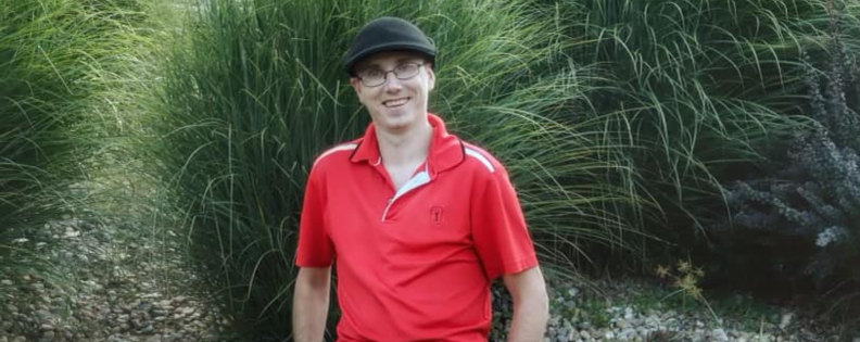 man standing in front of a bush smiling