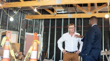 Butch Rigby from Screenland Real Estate having a conversation with an associate on a job site.