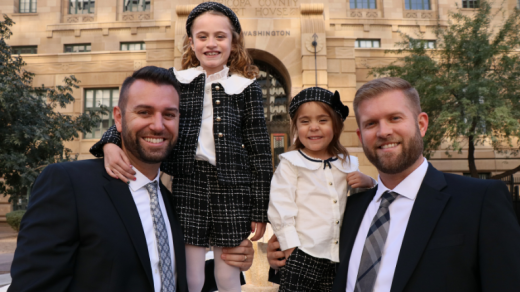 Two men and two children standing in front of building