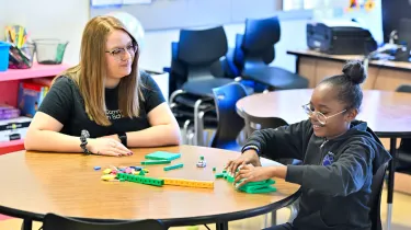Woman and young child sitting at a desk, 2024 Community Impact Report