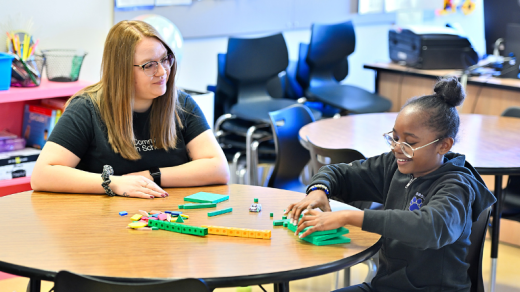 Woman and young child sitting at a desk, 2024 Community Impact Report