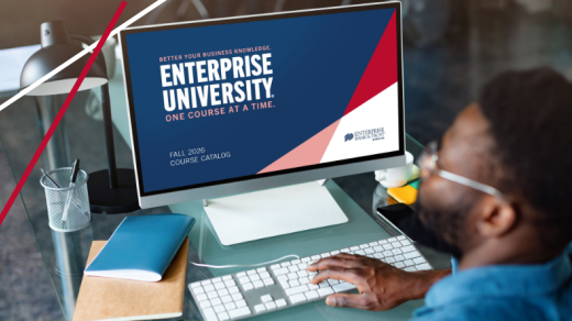 Man looking at a computer screen that has a large graphic with text: Better your business knowledge, Enterprise University, One course at a time. Fall 2026 Course Catalog, Enterprise Bank & Trust logo
