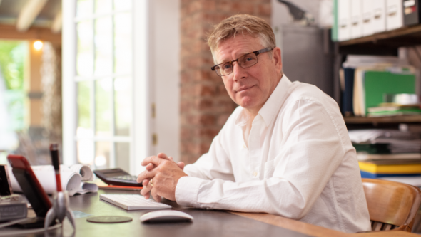 man sitting at desk while smiling