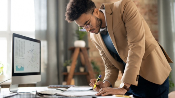 Man highlighting files in front of computer