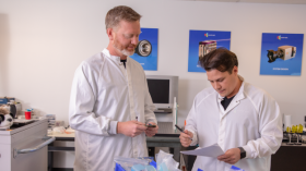 Two men in lab coats looking at data