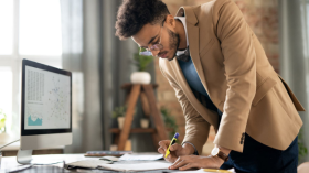 Man highlighting files in front of computer