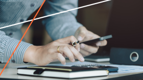 hands holding a phone and pen