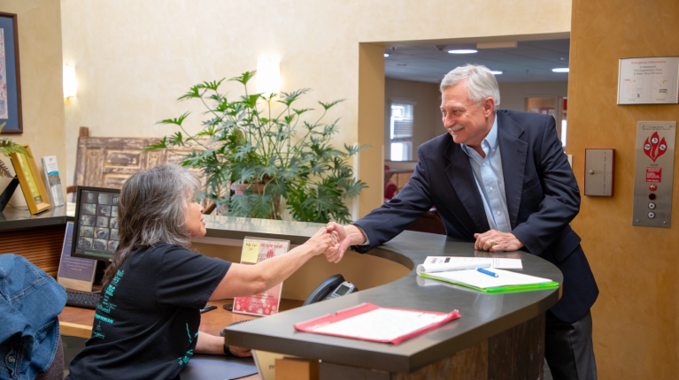 Woman and man shaking hands across a desk