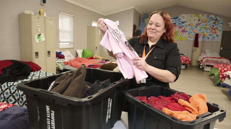 Woman sorting closes in bins, Community Partnerships Loaves & Fishes